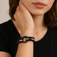 Bracelet mousqueton noir et rose en nylon triple cordon avec fermoir acier inoxydable sur poignet féminin.