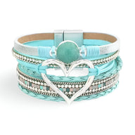Bracelet multi-rangs turquoise avec grand cœur argenté et perle centrale, fermoir magnétique.