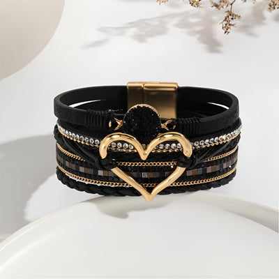 Bracelet multi-rangs noir avec grand cœur doré central et détails brillants, fermeture magnétique dorée.