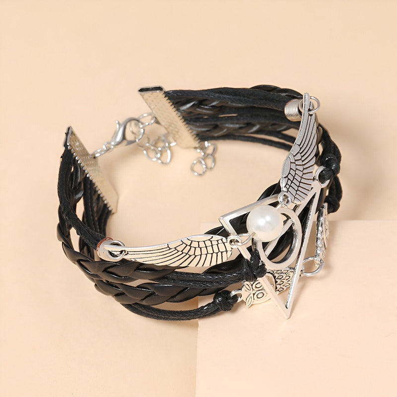 Bracelet multi-rangs en cuir noir tressé avec pendentifs ailes d'ange, hiboux et perle blanche.