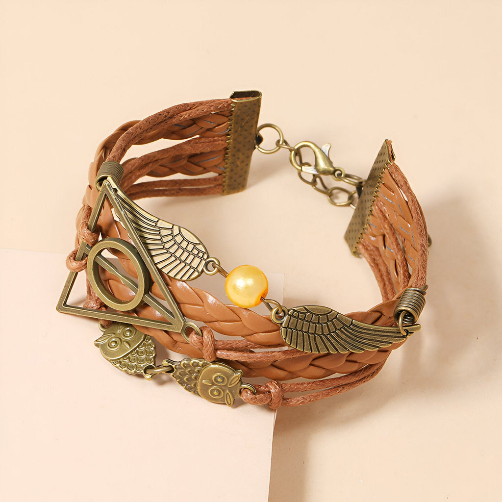 Bracelet multi-rangs marron en cuir tressé avec breloques hiboux, ailes d'ange et perle dorée.