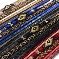 Bracelets multi-rangs perles et fils colorés en beige, bleu, noir et rouge, motifs géométriques dorés.