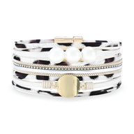 Bracelet multi-rangs léopard blanc et noir orné de perles blanches et éléments dorés.