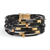 Bracelet multi-rangs noir à motif léopard avec détails dorés et fermoir magnétique.