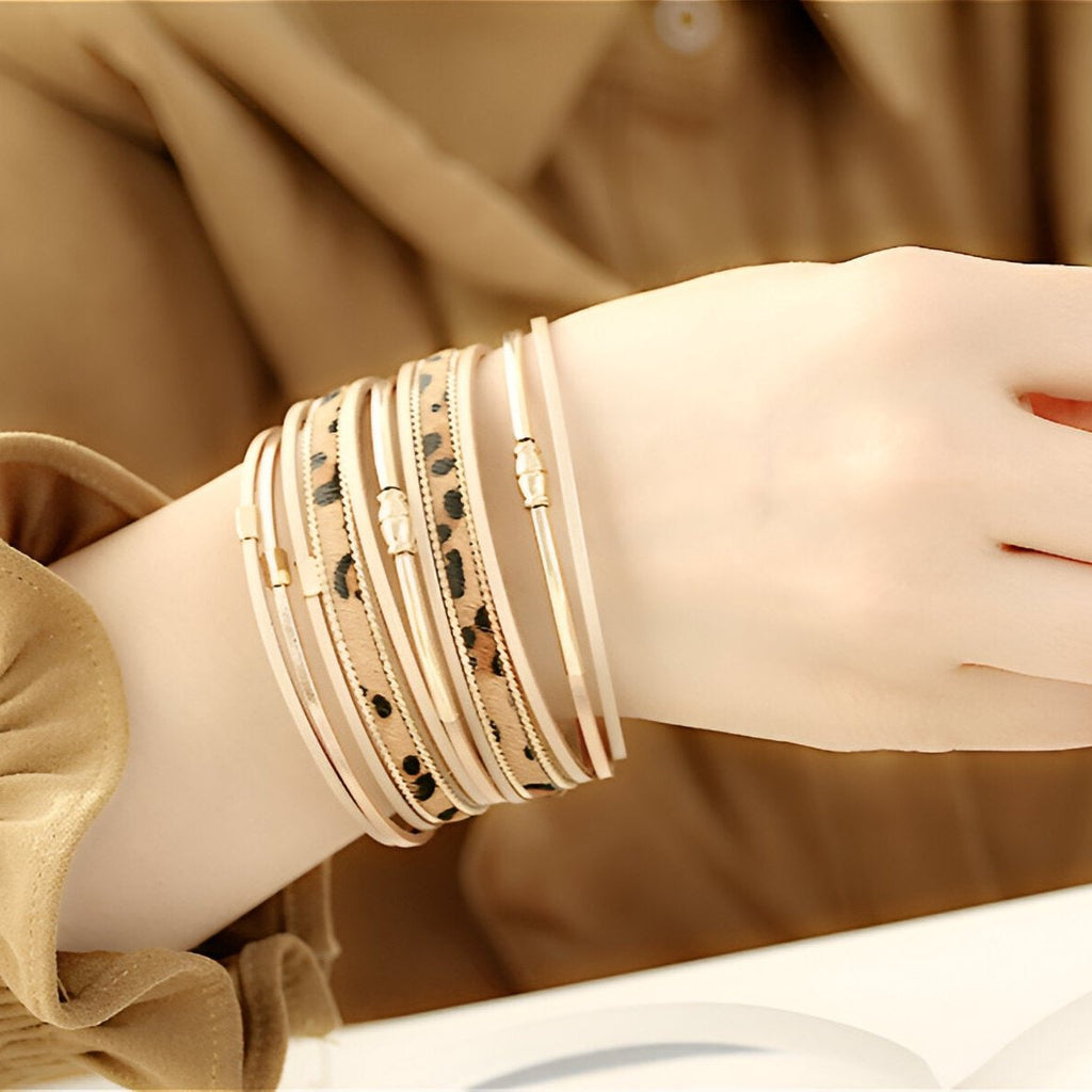 Bracelet multi-rangs beige avec motifs léopard noirs et dorés, style élégant et fin pour femme.