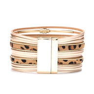 Bracelet multi-rangs en cuir marron avec motif léopard et fermoir doré brillant.