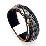 Bracelet multi-rangs effet léopard noir et gris avec détails dorés et fermoir métallique doré.