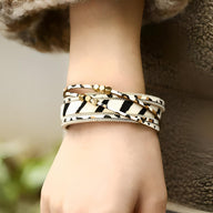 Bracelet multi-rangs femme en cuir beige et noir imprimé léopard avec perles dorées et fils tressés blancs.