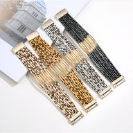 Quatre bracelets multi-rangs avec motifs léopard en beige, gris, marron et blanc, détails dorés.