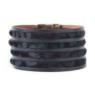 Bracelet multi-rangs noir avec motifs léopard subtils en cuir texturé.