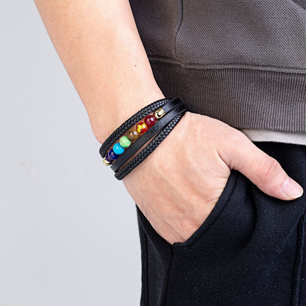 Bracelet multi-rangs en cuir noir avec perles colorées représentant les 7 chakras, porté homme.