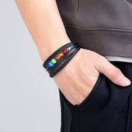 Bracelet multi-rangs en cuir noir avec perles colorées représentant les 7 chakras, porté homme.