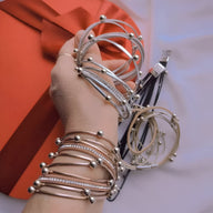 Bracelet multi-rangs argenté avec multiples breloques rondes et détails en perles fines.