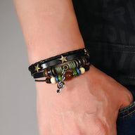 Bracelet multi-rangs en cuir noir avec étoiles dorées, perles colorées et pendentif note de musique.