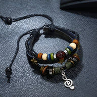 Bracelet multi-rangs en cuir noir avec perles colorées et pendentif note de musique argenté.