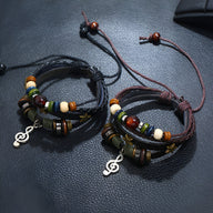 Bracelet multi-rangs en cuir noir avec perles colorées et pendant note de musique en métal argenté.