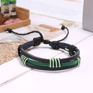 Bracelet multi-rangs en cuir noir avec détails verts tressés et fermeture ajustable en cordon.