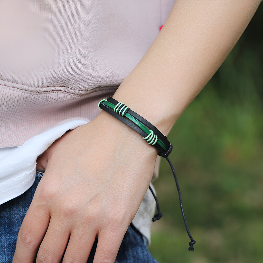 Bracelet multi-rangs en cuir noir et vert avec détails verts sur poignet masculin.