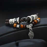 Bracelet multi-rangs en cuir microfibre noir avec perles en bois et breloque feuille argentée.