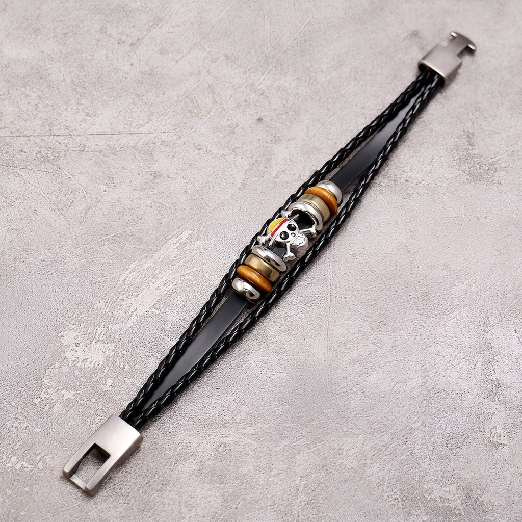 Bracelet multi-rangs en cuir noir avec motif tête de mort colorée et fermoir métallique argenté.