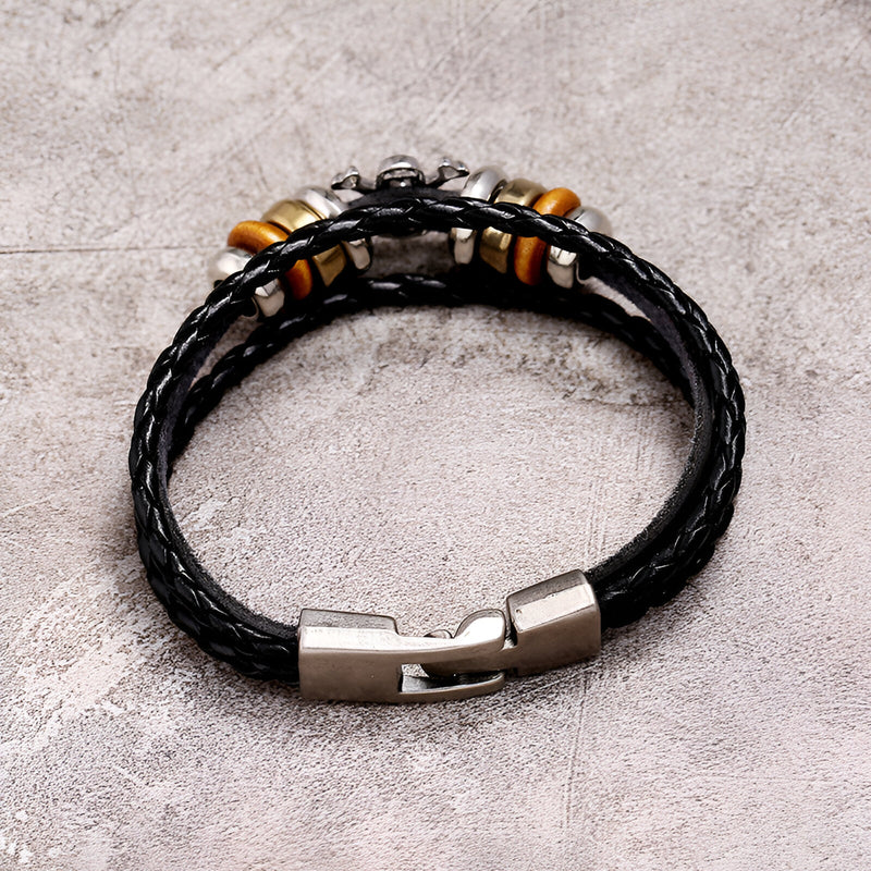Bracelet multi-rangs en cuir noir tressé avec fermoir métallique argenté et perles décoratives en bois et métal.