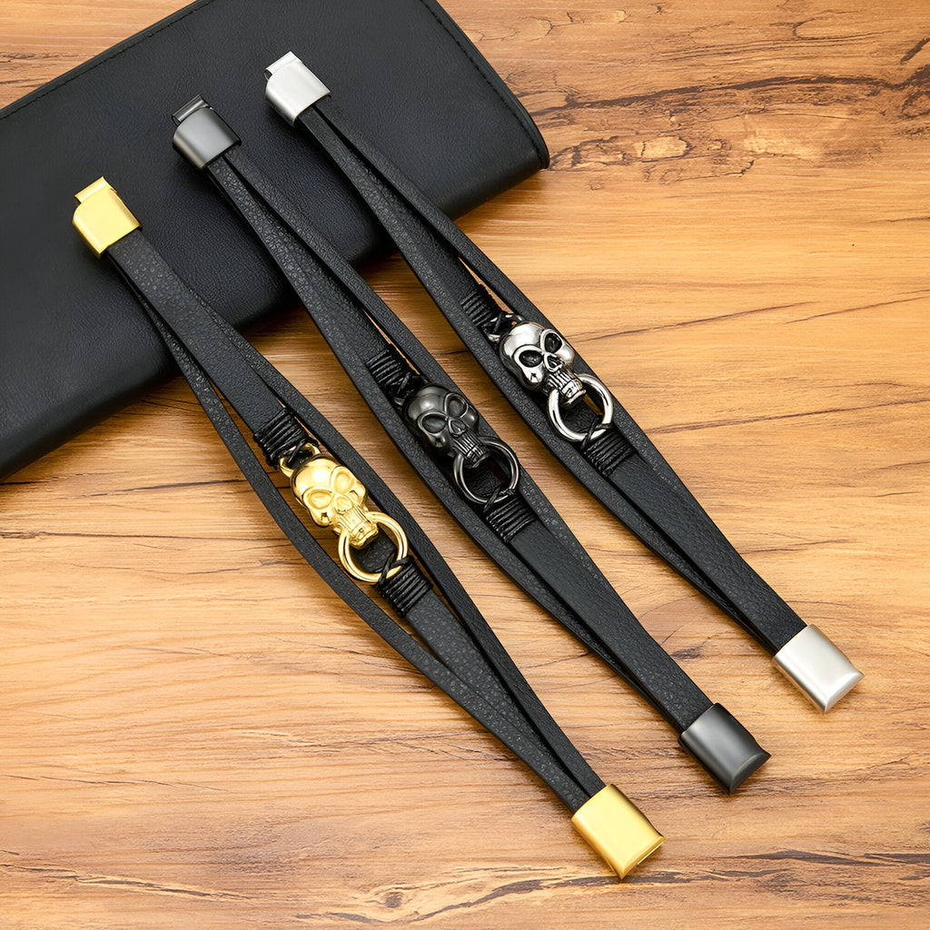 Bracelet multi-rangs en cuir noir avec tête de mort et anneau en métal or, noir ou argent, fermoir carré assorti.