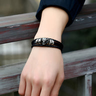 Bracelet multiple rangs en cuir noir avec tête de mort métallique homme.