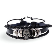 Bracelet multi-rangs en cuir noir avec tête de mort argentée et anneaux métalliques pour homme.