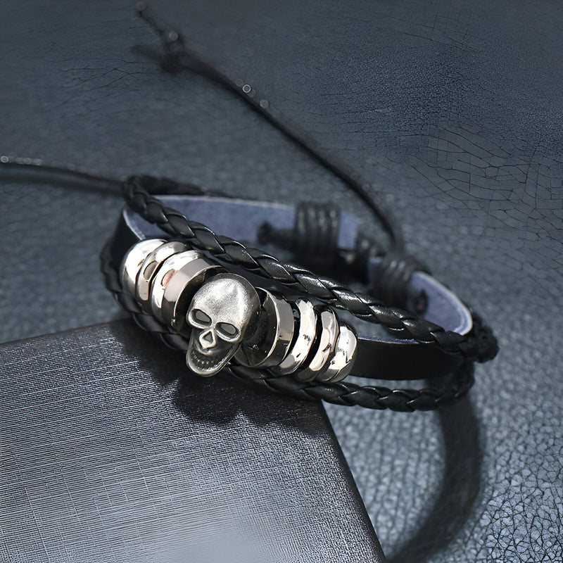 Bracelet multi-rangs en cuir noir avec tête de mort argentée et anneaux métalliques pour homme.