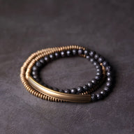 Bracelet multi-rangs cuivre et pierres volcaniques noires, perles rondes et barrette lisse dorée.