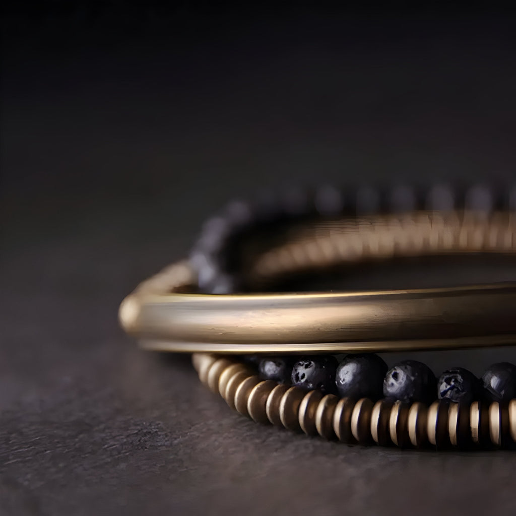 Bracelet multi-rangs en cuivre doré et pierres volcaniques noires, style bohème élégant.