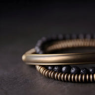 Bracelet multi-rangs en cuivre doré et pierres volcaniques noires, style bohème élégant.