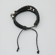 Bracelet multi-rangs noir en microfibre tressée avec plume métallique et fermoir coulissant.