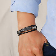 Bracelet multi-rangs noir en microfibre avec grande plume en métal et perles argentées.