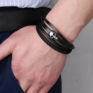 Bracelet multi-rangs noir en microfibre avec tête de mort argentée détaillée.
