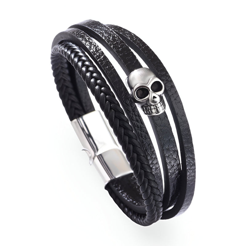 Bracelet multi-rangs noir en microfibre avec tête de mort argentée et fermeture aimantée.