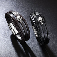 Bracelet multi-rangs en microfibre noir avec tête de mort argentée et fermoir métallique magnétique.