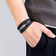 Bracelet multi-rangs noir en microfibre avec détails métalliques lisses et design moderne.