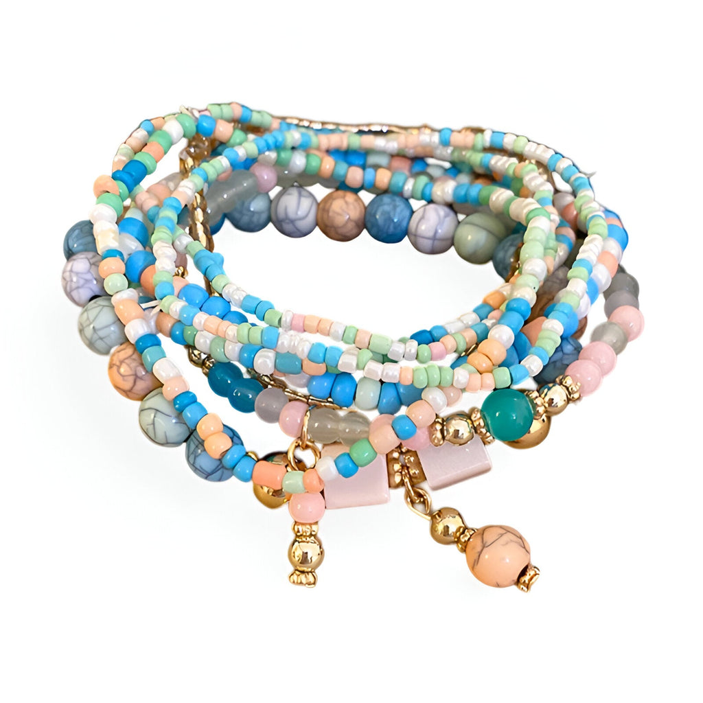 Bracelet multi-rangs élastique en perles résine bleu, beige, rose et vert avec petits pendentifs dorés.