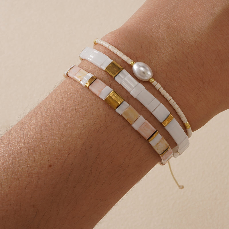 Bracelet multi-rangs perles crème et rose, perle coquillage ovale, détails dorés, fermoir réglable.