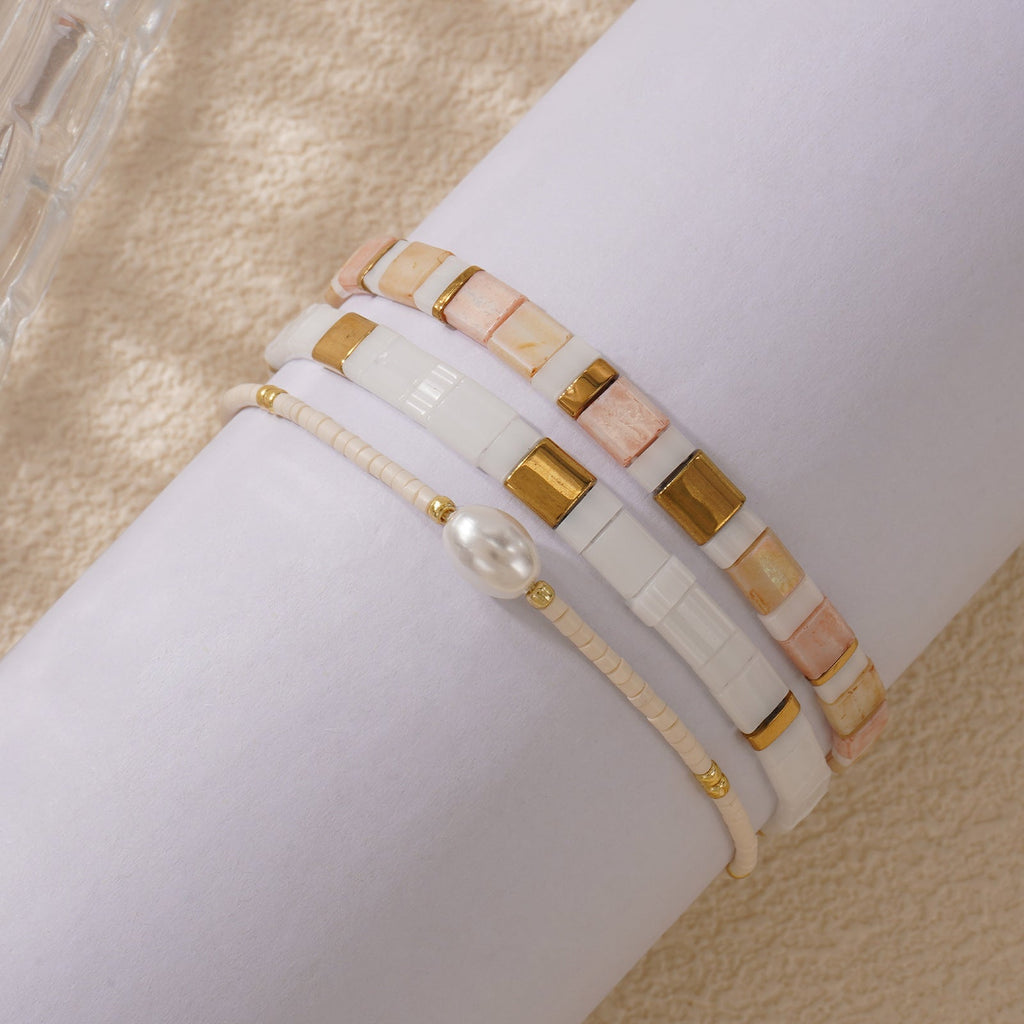 Bracelet multi-rangs perles crème et rose, perles coquillage, détails dorés, fermoir réglable.