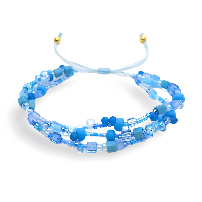 Bracelet multi-rangs en perles heishi bleu clair et bleu foncé avec cordon ajustable et perles dorées aux extrémités.