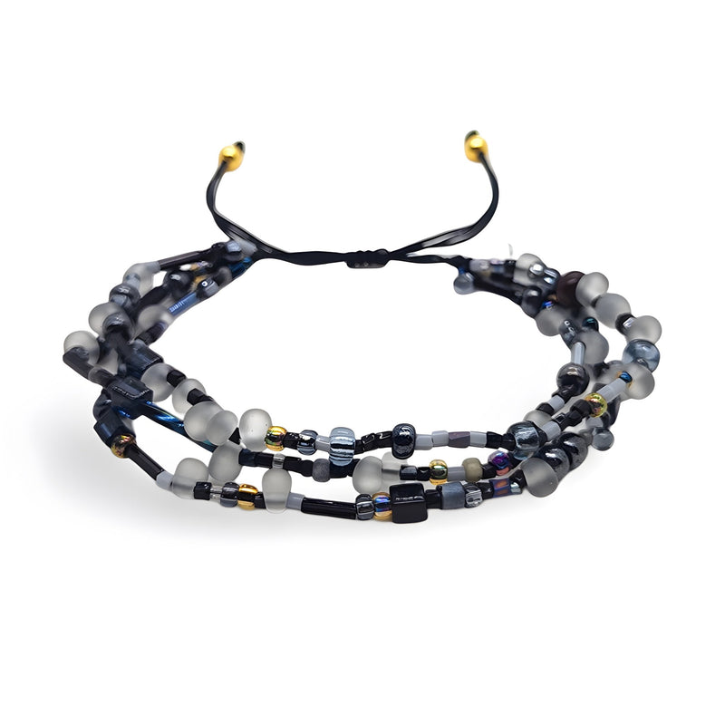 Bracelet multi-rangs en perles heishi noires et grises avec fils noirs et embouts dorés.