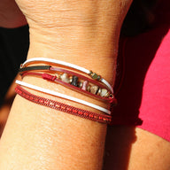 Bracelet multi-rangs rouge avec pierres naturelles et fines cordelettes bohèmes.