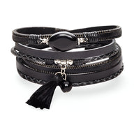 Bracelet multi-rangs noir avec pierre d'agate ovale noire et pompon en tissu noir.