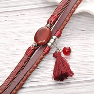 Bracelet multi-rangs rouge avec pierre d'agate ovale, pompon et détails argentés en métal.