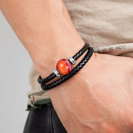 Bracelet multi-rangs noir en cuir tressé avec pierre d'agate orange et détails argentés.