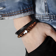 Bracelet multi-rangs homme avec pierres œil de tigre, cuir noir tressé et pendentif croix argenté.