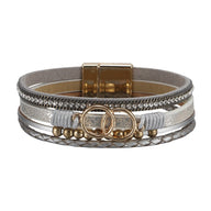 Bracelet multi-rangs gris en simili cuir avec strass, anneaux dorés décoratifs et fermoir magnétique doré.