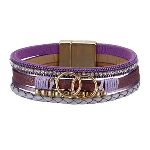 Bracelet multi-rangs violet et marron en simili cuir avec strass, perles dorées et anneaux dorés, fermoir magnétique.